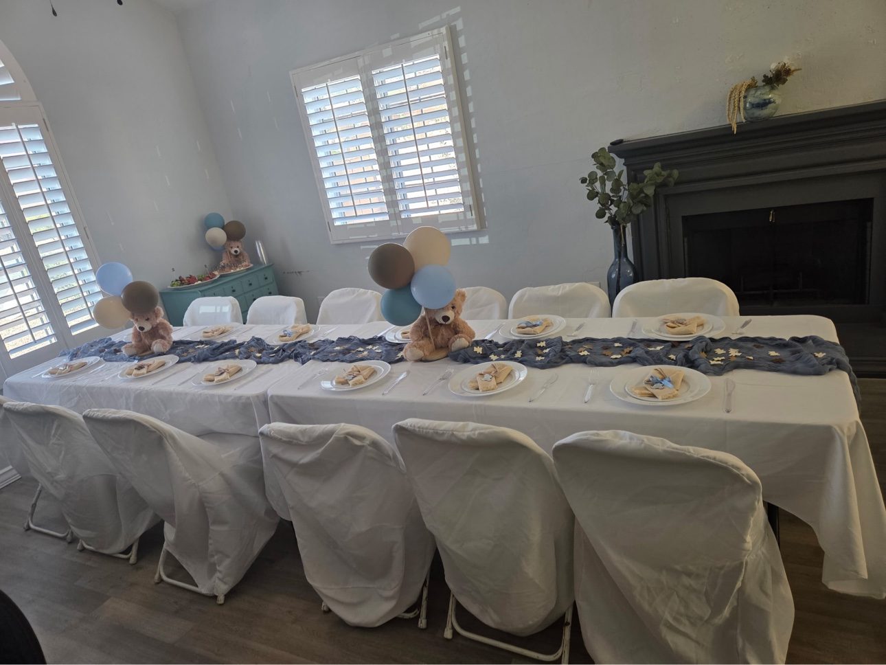 Baby shower table setup with white linens and chair covers by July's Rentals