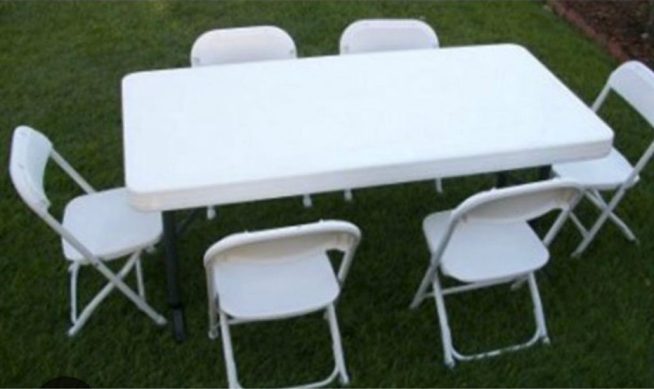 Rectangular table with 6 white folding chairs